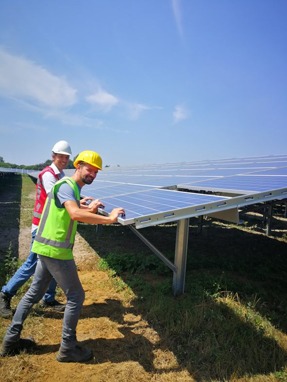 Twee bouwvakkers duwen een zonnepaneel